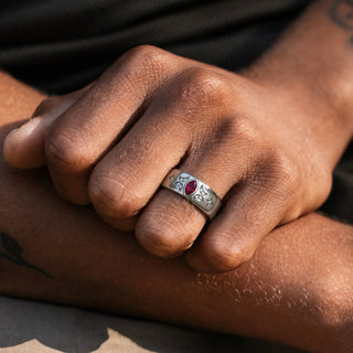 Man wearing the 6mm Ruby Celestial wedding band, bezel-set marquise ruby flanked by pave crescent moons and four-point star accents