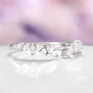 Silver ring with marquise-shaped gemstones on a soft, blurred background