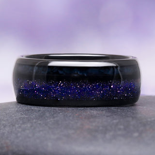 Black ring with blue glittery interior on a gray surface