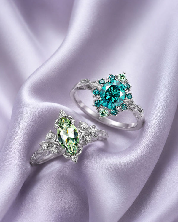 Teal round halo ring and green marquise leaf ring in sterling silver arranged on lilac satin, Aquamarise vertical collection banner