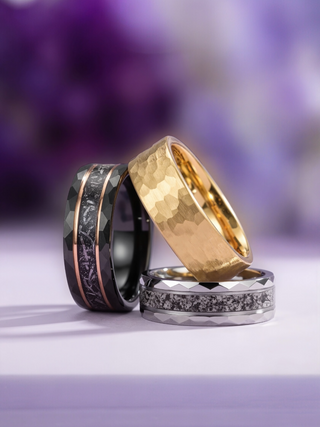 Three rings with different designs on a blurred purple background
