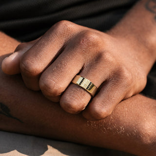 Man wearing the 8mm Viridian Leaf & Black Onyx men's wedding band in 14K yellow gold vermeil, carved leaf panel framed by black onyx channels