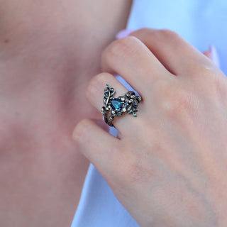 Close-up of the Wisteria pear alexandrite ring with black ruthenium leaf branches wrapping the finger