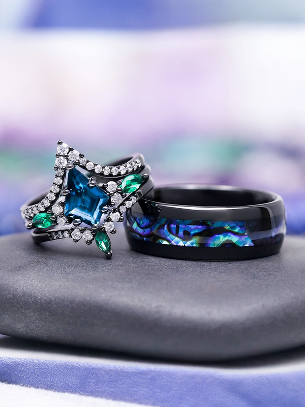 Two rings with star-shaped gemstones on a gray surface with a blurred background