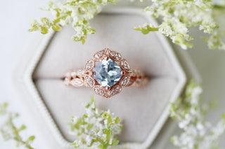 Art Deco Aquamarine Engagement Ring in Solid 14K Rose Gold by Aquamarise Gold featuring a cushion-cut aquamarine with intricate vintage halo and detailed rose gold band design.