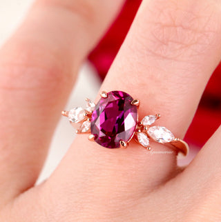 Eva Oval Cut Lab Grown Ruby Engagement Ring in 14K Rose Gold Vermeil by Aquamarise featuring an oval ruby centerpiece with marquise and pear-shaped simulated diamond accents in a vintage floral design.