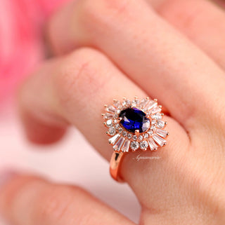 Victoria Vintage Blue Sapphire Engagement Ring in 14K Rose Gold Vermeil by Aquamarise featuring a vivid blue sapphire framed by sparkling baguette and round accents in a vintage Art Deco style.