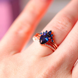 Dakota Teardrop Blue Sapphire Ring Set in 14K Rose Gold Vermeil by Aquamarise, featuring a teardrop sapphire centerpiece with smaller sapphires and pavé diamond band in rose gold vermeil.